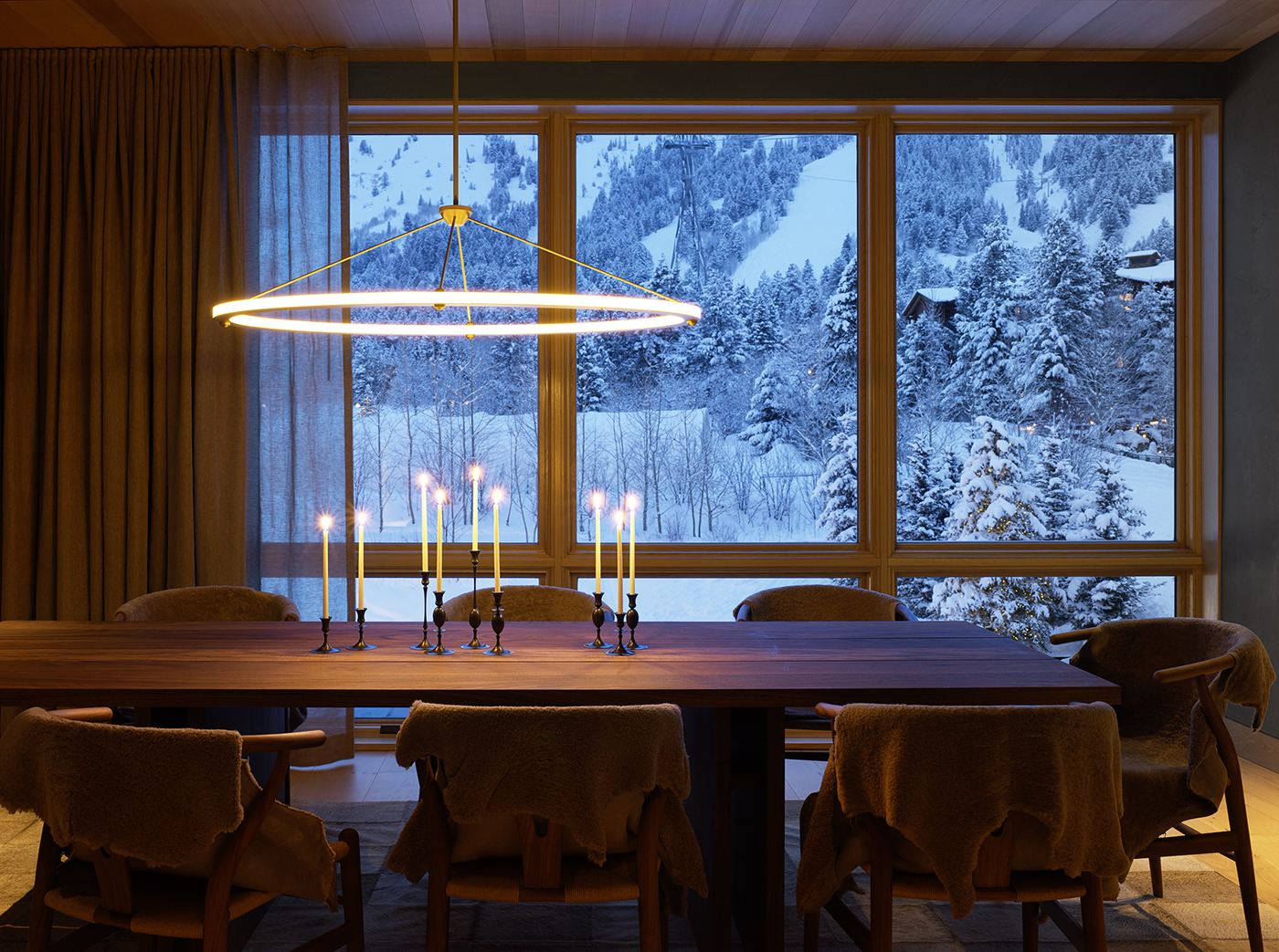 A house in the mountains surrounded by snow with custom lights