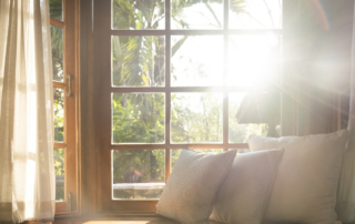 Living room with part of sofa in sunny day and white curtain.